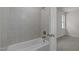 Bathroom with tiled walls, shower head, bathtub, and open doorway to another room at 132 Cotten Dr, Morrisville, NC 27560