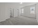 Neutral bedroom features gray carpet, neutral walls, and an open doorway leading to another room at 132 Cotten Dr, Morrisville, NC 27560