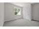 Bedroom with neutral walls, gray carpet, large windows providing great natural light, and a closet at 132 Cotten Dr, Morrisville, NC 27560