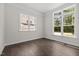 Bright bedroom with hardwood floors, white trim, and large windows overlooking the front yard at 132 Cotten Dr, Morrisville, NC 27560