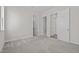 Neutral bedroom features gray carpet, neutral walls, base trim, and two open doorways at 132 Cotten Dr, Morrisville, NC 27560