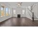 Open living room features hardwood floors, many windows, staircase, and a modern fireplace at 132 Cotten Dr, Morrisville, NC 27560