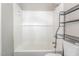 Bathroom featuring a white tiled bathtub and a black shelving unit for storage at 1401 Robinhood Rd, Durham, NC 27701