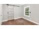 A bedroom showcasing hardwood floors, a window and a decorative sliding barn door at 1401 Robinhood Rd, Durham, NC 27701
