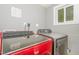 A laundry room boasts modern, red and grey machines for efficient washing and drying at 1401 Robinhood Rd, Durham, NC 27701