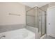 Bright bathroom featuring a soaking tub, a separate shower with glass door, and tiled walls at 1416 Southpoint Trl, Durham, NC 27713
