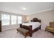 Bedroom featuring tray ceiling, a large window, and a stylish bed with bench at 1416 Southpoint Trl, Durham, NC 27713
