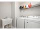 Functional laundry room with modern washer, dryer, and storage shelves at 1416 Southpoint Trl, Durham, NC 27713