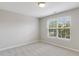 Bright bedroom with neutral walls, carpet and a large window that fills the room with natural light at 160 Chandler Springs Dr, Holly Springs, NC 27540