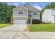 Charming two-story home showcasing neutral siding, a two-car garage, and well-manicured lawn at 160 Chandler Springs Dr, Holly Springs, NC 27540