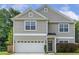 Charming two-story home showcasing neutral siding, a two-car garage, and well-manicured lawn at 160 Chandler Springs Dr, Holly Springs, NC 27540