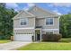 Charming two-story home showcasing neutral siding, a two-car garage, and well-manicured lawn at 160 Chandler Springs Dr, Holly Springs, NC 27540