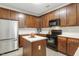 Kitchen with stainless steel refrigerator, dark cabinets and neutral countertops at 160 Chandler Springs Dr, Holly Springs, NC 27540