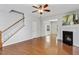 Bright living room featuring hardwood floors, fireplace, ceiling fan, and staircase access at 160 Chandler Springs Dr, Holly Springs, NC 27540