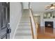 Carpeted staircase leading to the upper level with a view of the living room fireplace at 160 Chandler Springs Dr, Holly Springs, NC 27540