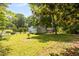 Large, lush backyard featuring a spacious lawn, mature trees, and partial fencing at 1605 Nixon St, Durham, NC 27707