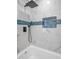 Bathroom featuring a tile shower with rainfall shower head, blue accent tile, and niche at 1605 Nixon St, Durham, NC 27707