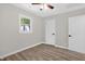 Bedroom featuring a ceiling fan, new wood flooring, and a white door with black hardware at 1605 Nixon St, Durham, NC 27707