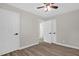 Bedroom featuring hardwood floors, fresh paint, three doors, and a ceiling fan at 1605 Nixon St, Durham, NC 27707