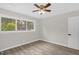 Bedroom featuring hardwood floors, ceiling fan, large window, fresh paint, and a door at 1605 Nixon St, Durham, NC 27707