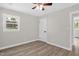 Bedroom with hardwood floors, fresh paint, ceiling fan, one window, and a door at 1605 Nixon St, Durham, NC 27707