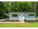 Charming exterior view of the light blue home featuring manicured landscaping and covered parking at 1605 Nixon St, Durham, NC 27707