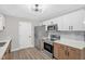 Updated kitchen featuring stainless steel appliances, stylish lighting, and modern backsplash at 1605 Nixon St, Durham, NC 27707