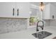 Close up of kitchen showing granite countertops, tile backsplash, black hardware and fixtures, and stainless steel sink at 1605 Nixon St, Durham, NC 27707