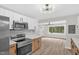 Bright open kitchen with stainless steel appliances and hardwood floors leading to living room at 1605 Nixon St, Durham, NC 27707