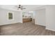 Open-concept living room with kitchen view, hardwood floors, ceiling fan, and natural light at 1605 Nixon St, Durham, NC 27707