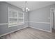 Dining room with a modern light fixture, laminate flooring, large window, and ample natural light at 161 Bridgewater Dr, Erwin, NC 28339