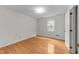 Bright bedroom featuring hardwood floors, a window, and a door at 204 Chatterson Dr, Raleigh, NC 27615