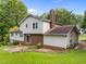 View of the rear of the home with a brick chimney and siding, overlooking the backyard and green lawn at 204 Chatterson Dr, Raleigh, NC 27615