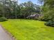 Expansive green lawn with mature trees surrounding a charming two-story home with traditional architecture at 204 Chatterson Dr, Raleigh, NC 27615