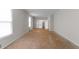 Bright living room with unfinished wood floors, two windows and a staircase in the background at 204 Chatterson Dr, Raleigh, NC 27615
