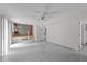 Open living room, featuring a ceiling fan, access to a second story, and bright windows at 204 Chatterson Dr, Raleigh, NC 27615