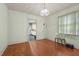Elegant dining room with hardwood floors, a decorative chandelier, and ample natural light from large windows at 212 Plum St, Burlington, NC 27215