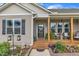 Inviting front porch with rocking chairs and decorative plants, enhanced by meticulously landscaped garden beds at 272 W Gennessee Dr, Zebulon, NC 27597