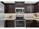 Modern kitchen featuring stainless steel appliances, dark cabinets, and ample counter space for cooking and entertaining at 272 W Gennessee Dr, Zebulon, NC 27597