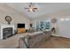 Bright and airy living room featuring a fireplace, large windows, and comfortable seating under a ceiling fan at 272 W Gennessee Dr, Zebulon, NC 27597