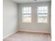This bedroom features plush carpeting, neutral walls, and two bright windows at 2735 Hunter Woods Dr # 571, Apex, NC 27502