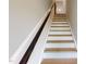 Bright staircase featuring wood treads and a dark wood handrail at 2735 Hunter Woods Dr # 571, Apex, NC 27502