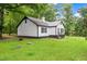 Charming white home with black trim, metal roof and a green lawn at 2809 Titleist Dr, Hillsborough, NC 27278