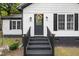 Close up of the front door entrance, black trim, brick steps and decorative wreath at 2809 Titleist Dr, Hillsborough, NC 27278