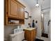 A compact bathroom features a wood vanity, overhead shelving, and tiled flooring at 301 W Thorndale Dr, Oxford, NC 27565