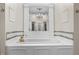 Elegant bathtub with a gold faucet, framed mirror and white paneling at 301 W Thorndale Dr, Oxford, NC 27565
