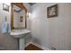A charming powder room with pedestal sink, decorative mirror, and patterned wallpaper at 301 W Thorndale Dr, Oxford, NC 27565