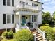 Elegant home featuring a welcoming front porch, with a light blue door and manicured landscaping at 301 W Thorndale Dr, Oxford, NC 27565