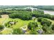 Aerial view of multiple luxury homes surrounded by mature trees and a glimpse of the lake in the distance at 310 Hidden Lake Dr, Youngsville, NC 27596