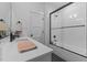 Well-lit bathroom with a sleek, black-framed glass shower, white countertop, and stylish decor at 310 Hidden Lake Dr, Youngsville, NC 27596